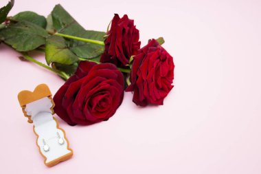 Kırmızı güller, güzel bir kutuda hediye edilen küpeler.