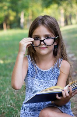 Kitabı olan küçük mutlu kız.