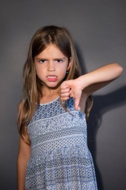 Küçük kız baş parmağını aşağı gösteriyor.