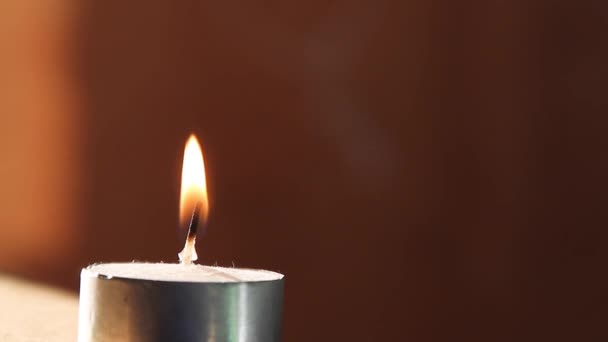 Одиночный свечной огонь, изолированный на деревянном фоне — стоковое видео