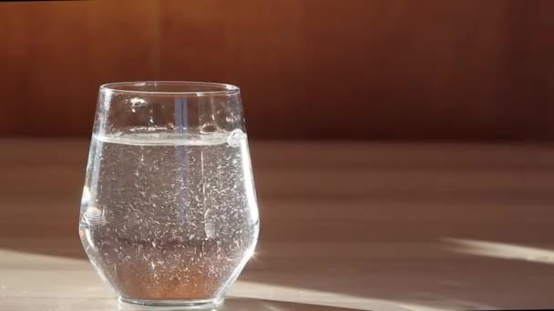 Tablet vitamin C dilempar ke dalam gelas transparan dengan air. — Stok Video
