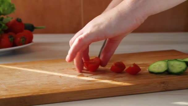 Cook corta tomate cereja e pepino com faca de cozinha na placa de corte de madeira — Vídeo de Stock