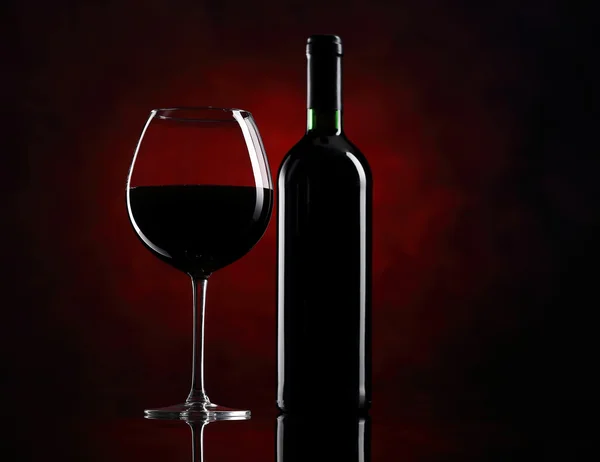 Rood wijnglas met fles Stockfoto