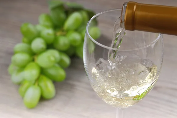 Pouring white wine and grape — Stock Photo, Image