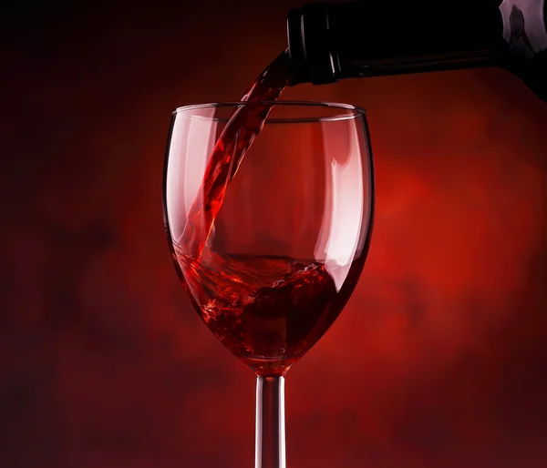 Rode wijn in glas gieten Rechtenvrije Stockafbeeldingen