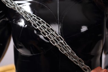 Lateks kostüm zinciri tutan kadın