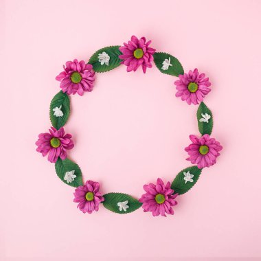 Pembe ve beyaz çiçeklerden yapılmış güzel doğal yuvarlak çerçeve ve pastel arka planda fotokopi alanı olan yeşil yapraklar. Düz yatıyordu mevsimlik tebrik kartı tasarımı. 