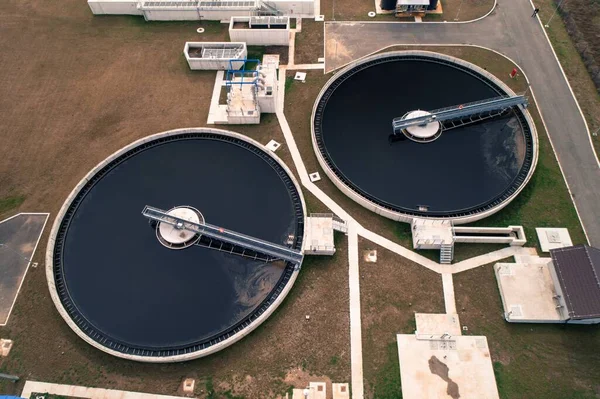 Water treatment facility pools tanks reservoirs. Waste water separation. Winter. Aerial drone shot. Agricultural fields around.