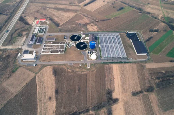 Water treatment facility Waste water being recycled into fuel. Aerial drone shot. Agricultural fields around. Winter. High point of view.