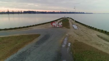 Palic Gölü kıyıda aşk kalbi işareti. Sahil evleri ve restoranlar. Güzel bir tatil köyü. Göl kıyısında gezinti..