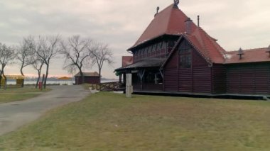 Palic Gölü sahil evleri. Kamera yükseliyor. Sahil evleri ve restoranlar. Güzel bir tatil köyü. Göl kıyısında gezinti..