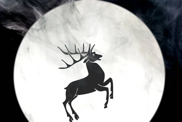 Silhouette of a black deer on the background of the night moon