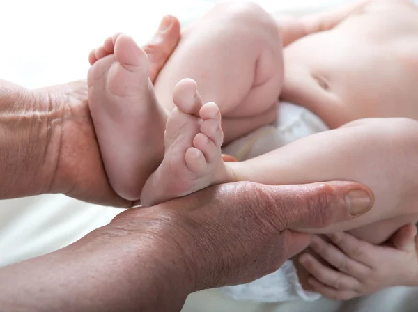 Grootmoeder gebreide baby sokken warm, zorg voor het kind — Stockfoto