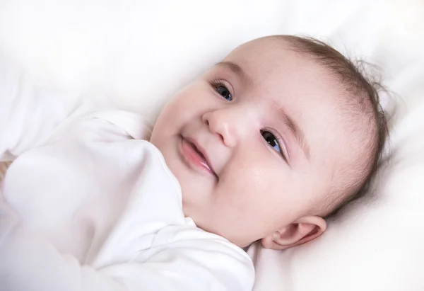 Criança brincando em uma cama — Fotografia de Stock