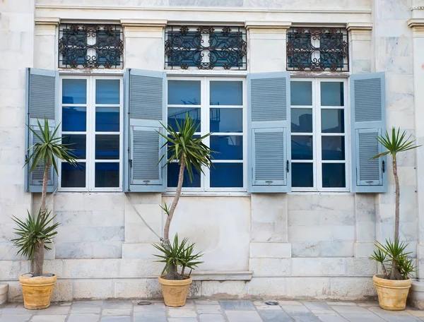 Τρεις μπλε παράθυρα και φυτών σε γλάστρες μια — Φωτογραφία Αρχείου