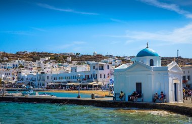 Bir iskele üzerinde kilise yakınında oturan insanlar
