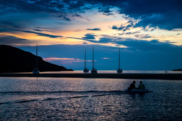 Menschen im Boot bei Sonnenuntergang — Stockfoto