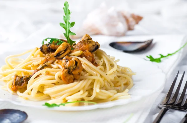 Pasta with mussels and arugula — Stock Photo, Image