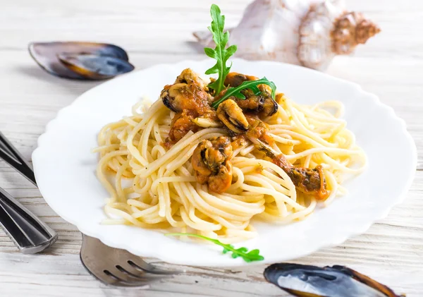 Pasta with mussels and arugula — Stock Photo, Image