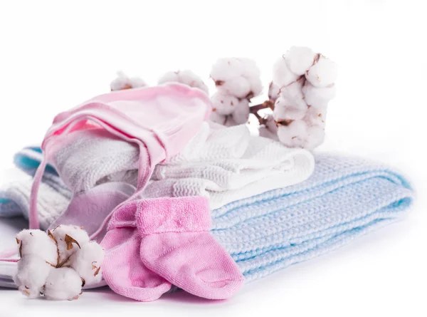 Cotton buds and knitted baby clothes — Stock Photo, Image