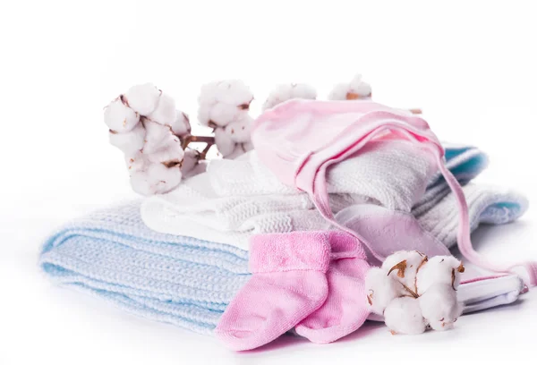Cotton buds and knitted baby clothes — Stock Photo, Image