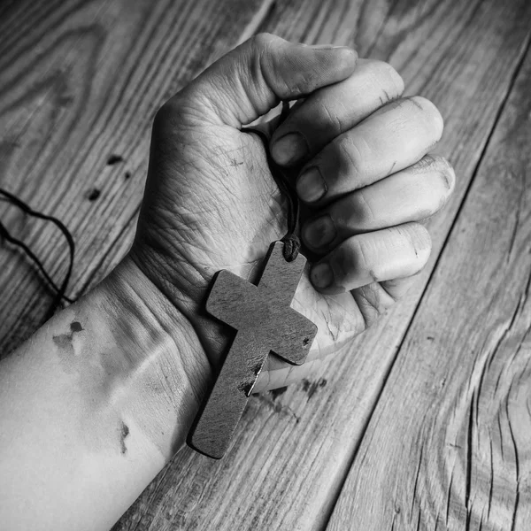 Cross in hand on wood — Stock Photo, Image