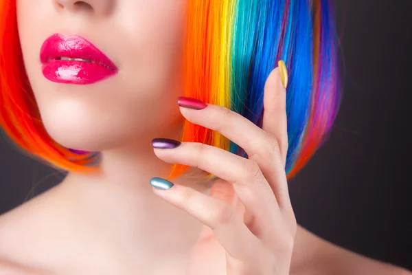 Piękna kobieta nosi kolorowe peruki i przedstawienie kolorowe paznokcie — Zdjęcie stockowe