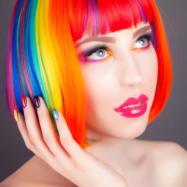 Piękna kobieta nosi kolorowe peruki i przedstawienie kolorowe paznokcie — Zdjęcie stockowe