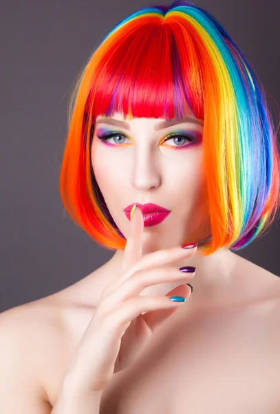 Bela mulher vestindo peruca colorida e mostrando unhas coloridas — Fotografia de Stock