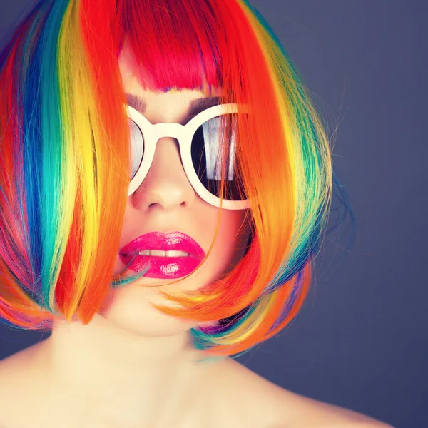 Vacker kvinna klädd i färgglada peruk och vita solglasögon — Stockfoto