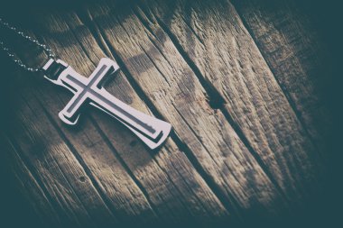 Ahşap arka plan üzerinde gümüş haç