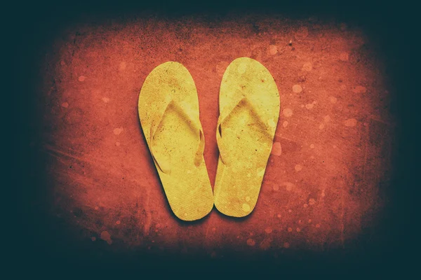 Yellow flip flops on a red background — Stock Photo, Image