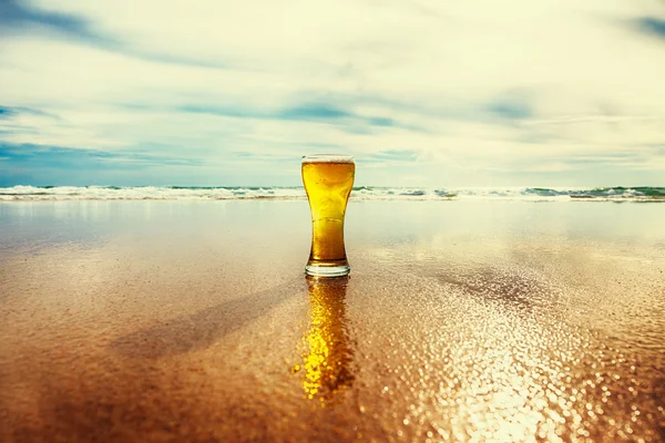 Vaso de cerveza sobre fondo marino — Foto de Stock
