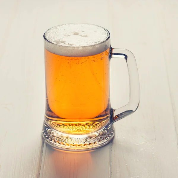 Mug of beer on table — Stock Photo, Image