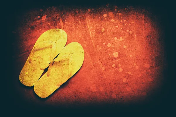 Gele flip-flops op een rode achtergrond — Stockfoto