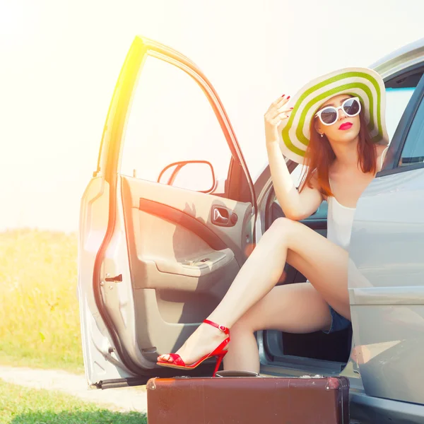 Vrouw zitten in auto met koffer — Stockfoto