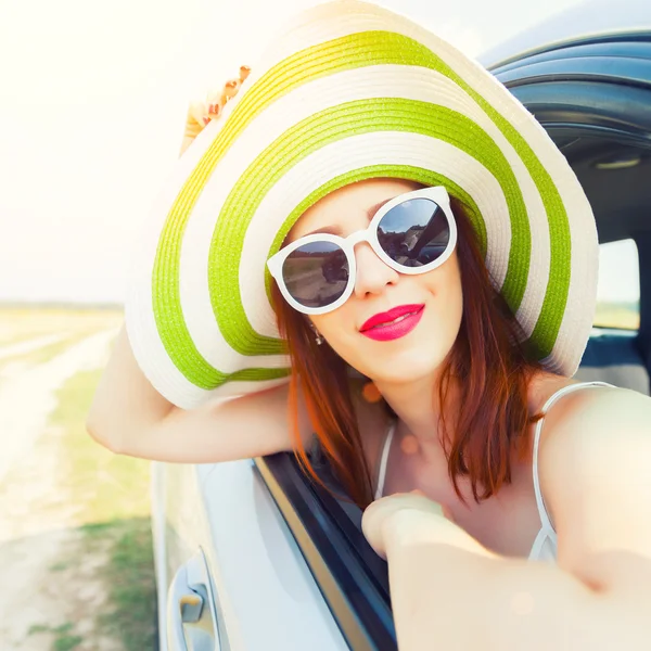 Gelukkige vrouw uit auto raam leunend — Stockfoto