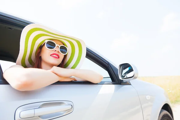 Mujer feliz inclinada por la ventana del coche — Foto de Stock