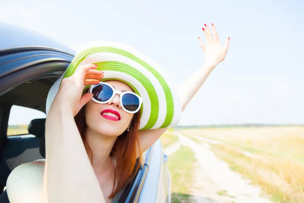 Gelukkige vrouw uit auto raam leunend — Stockfoto