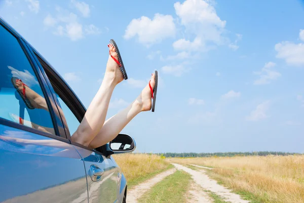 車の窓からぶら下がっている女性の足 — ストック写真