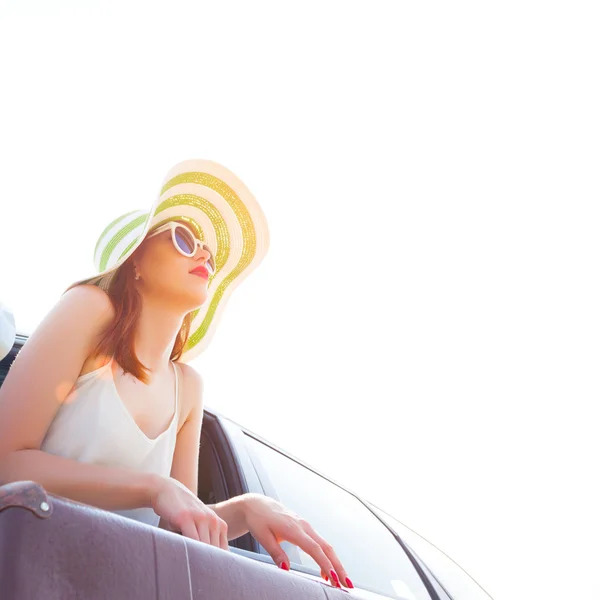 Happy woman looks out the car window — Stock Photo, Image