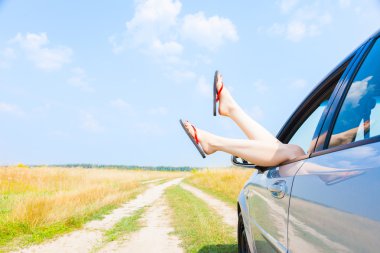 açık araba penceresinden sarkan bacakları