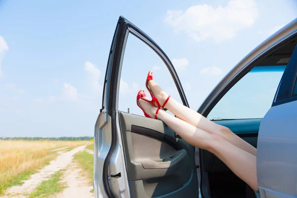Mooie vrouw benen in de auto — Stockfoto