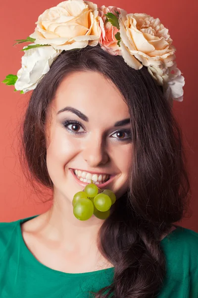 Mulher jovem vestindo grinalda e segurando uvas verdes — Fotografia de Stock