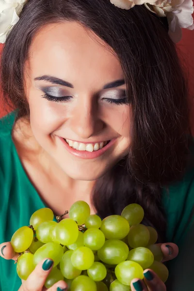 Mujer joven con corona y sosteniendo uvas verdes — Foto de Stock