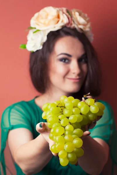 Mujer joven con corona y sosteniendo uvas verdes — Foto de Stock