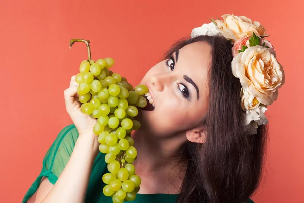 Mujer joven con corona y sosteniendo uvas verdes — Foto de Stock