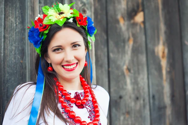 Kobieta ubrana Narodowy ukraiński ubrania siedzi w drewnianym baraku — Zdjęcie stockowe