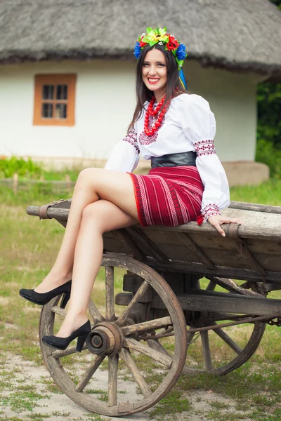 Femme portant des vêtements ukrainiens nationaux assis sur un vieux cheval tiré chariot en bois — Photo