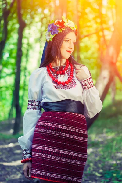 Женщина в национальной украинской одежде позирует в лесу — стоковое фото